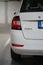 Close-up shot of an immaculate white sedan parked in the designated area of a parking garage