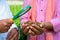 Close up shot of indian agro scientist hands checking soil from famer hand at greenhouse using magnifying glass -