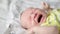 Close-up shot of infant crying. small caucasian baby yelling. Cute small baby. Cinematic shot of child crying