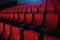 Close up shot of interior of cinema auditorium with lines of red chairs