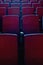 Close up shot of interior of cinema auditorium with lines of red chairs in front of a big screen