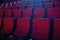 Close up shot of interior of cinema auditorium with lines of red chairs in front of a big screen