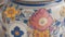 A close-up shot of an intricately designed ceramic vase with colorful floral patterns