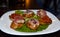 Close up shot of Italian style bruschetta, various mixed meat and vegetables on toasted slices of bread, healthy food for brunch