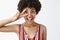 Close-up shot of joyful optimistic and happy disco girl with afro hairstyle in striped blouse showing victory or peace