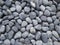 Close-up shot of a large pile of grey stones on a stone walkway in a park.