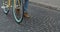 Close Up Shot of Legs in Jeans and Casual Boots Walking on the Old Stone Pawment near Modern Yellow Thin Tire Bike. Side