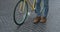 Close Up Shot of Legs in Jeans and Casual Boots Walking on the Old Stone Pawment near Modern Yellow Thin Tire Bike. Side