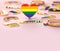 Close up shot on LGBT rainbow heart standing on pastel pink background. Copy space for your text. 3D rendering