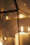 Close up shot of a lit candle in a geometric wire candle holder reflected in glass
