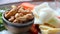 Close-up shot of a little bowl of cashew nuts and vegetables in the background.