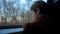 Close-up shot of a little curious boy looking out of the window in train. It`s raining outside, child reflecting in the