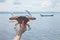 Close up shot of living crab in hand with background of sea, shore and fishery ship ins summer time shows sustainable tourism