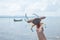 Close up shot of living crab in hand with background of sea, shore and fishery ship ins summer time shows sustainable tourism