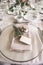 Close up shot of a luxury alfresco wedding reception table set up at the countryside; crystal tableware and a napkin