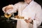 Close up shot of man pouring olive oil in prepared meal