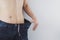 Close up shot of man with slim body measuring his waistline and torso. Healthy nutrition, diet and weight losing concept