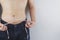 Close up shot of man with slim body measuring his waistline and torso. Healthy nutrition, diet and weight losing concept