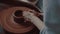 Close-up shot of a master female potter molding wet clay into a bowl on spinning potter`s wheel.