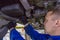 Close-up shot of a mechanic working under a car at the garage. Technician wearing blue coverall and using a wrench. Car is on a