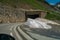 Close-up shot of melting dirty snow next to a tunnel in a hill