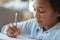 Close up shot of mixed race teen girl looking focused, writing with a pencil while doing homework, spending time at home