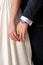 Close up shot of newlyweds holding hands. Just married husband and wife wedding rings close up.