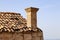 Close up shot of an old roof of shingles with chimney