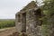 Close-up shot of old stone ruins of a forgotten lodge surrounded by trees on a cloudy day