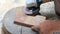 Close up shot  of old worker hands carpenter equals polishes wooden board with a random orbit sander in the workshop, sanding vint