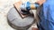 Close up shot  of old worker hands carpenter equals polishes wooden board with a random orbit sander in the workshop, sanding vint