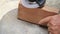 Close up shot  of old worker hands carpenter equals polishes wooden board with a random orbit sander in the workshop, sanding vint