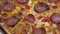 Close up shot over rotating pizza salami