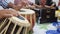 Close up shot of pair of hands playing indian classical music instrument tabla and playing of harmonium in background