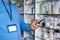 close up shot of Pharmacist busy using mobile phone at retail pharma medical store with copy space - concept of taking