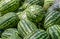 Close up shot of a pile of watermelons inside of a fruit shop