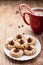 Close up shot of plate of peanut blossom chocolate cookies and hot chocolate in background