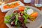 Close up shot of a plate of vegetable salad and smoke salmon slice