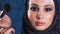 Close up shot of the portrait of Muslim woman, who is powdered with a brush