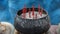 A close-up shot of a pot embroidered with red incense sticks in a Thai temple.