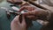 Close-up shot of professional artisan businesswoman hands sewing a handmade leather cover on modern workshop tool table.