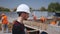 Close up shot of Professional Construction Worker Wearing Hard Hat Holds Tablet Computer, Standing in Modern Industrial