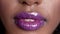 Close up shot on purple glowing wet makup lips of beautiful African fashion model