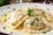 Close-up shot of Ravioli stuffed with crab meat and topped with creamy alfredo sauce, garnished with parsley