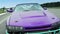 Close-up shot of real classic luxury sports car in purple color on a race track