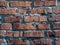 A close-up shot of a rough brick masonry wall lined with red clumsy brick for creativity, textures and background.