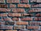 A close-up shot of a rough brick masonry wall lined with red clumsy brick for creativity, textures and background.