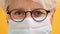 Close up shot of sad old woman with glasses and medical mask. Protect vulnerable people