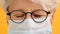 Close up shot of sad old woman with glasses over closed eyes and medical mask. Protect vulnerable people