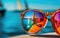 Close-up shot of a sailor\\\'s sunglasses on a harbor reflecting sailboats